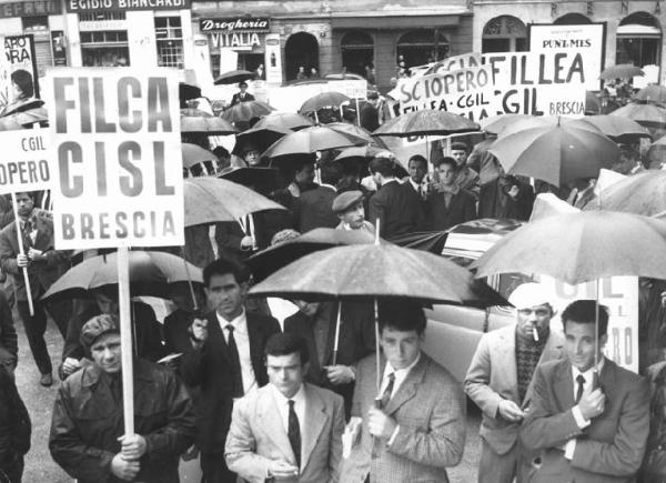 Sciopero nazionale dei lavoratori edili - Manifestazione regionale a Milano sotto la pioggia - Lavoratori al comizio - Striscioni - Cartelli di sciopero Filca Cisl, Fillea Cgil