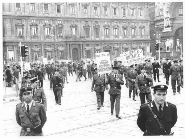 Sciopero delle guardie giurate e dei metronotte - Corteo in piazza della Scala davanti a Palazzo Marino - Lavoratori in divisa - Cartelli sindacali di sciopero e di protesta - Monumento a Leonardo da Vinci