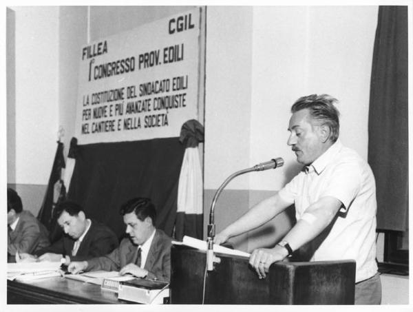 Camera del Lavoro - Sala "Bruno Buozzi" - Interno - Congresso provinciale edili - Tavolo della presidenza con, tra i sindacalisti, Lauro Casadio - Oratore al microfono - Parola d'ordine del congresso