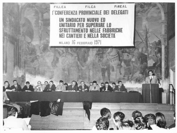 Salone degli affreschi della Società Umanitaria - Interno - Conferenza provinciale unitaria dei delegati - Tavolo della presidenza con oratori - Parola d'ordine della conferenza