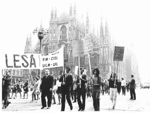 Occupazione della Lesa contro le speculazioni aziendali e il licenziamento dei lavoratori - Corteo dei lavoratori in piazza del Duomo - Striscione - Cartelli - Il Duomo