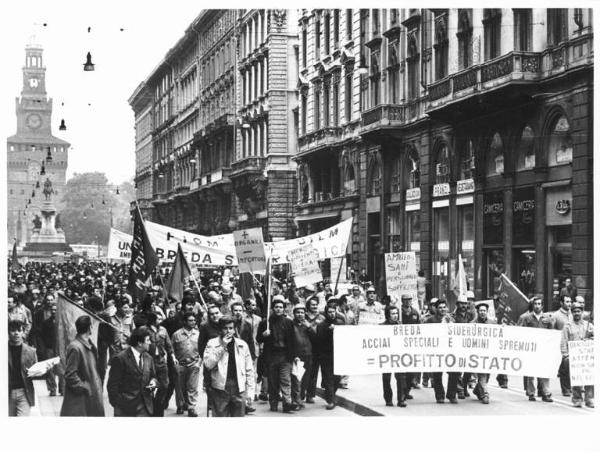 Sciopero dei lavoratori della Breda Siderurgica per l'ambiente di lavoro - Corteo in via Dante - Operai con tuta da lavoro - Striscione - Cartelli - Bandiere Fim, Fiom, Uilm - Monumento a Garibaldi sullo sfondo