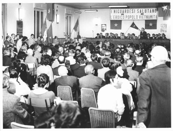 Sala a Niguarda - Interno - Assemblea con una delegazione del Vietnam - Panoramica sulla sala - Tavolo della presidenza - Platea - Bandiere - Parola d'ordine