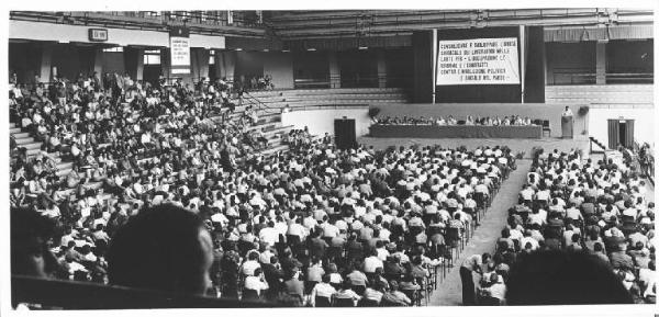 Palazzetto dello Sport - Interno - Congresso straordinario provinciale della Camera Confederale del Lavoro - Panoramica sulla sala - Platea e tavolo della presidenza - Lucio De Carlini al microfono - Parola d'ordine