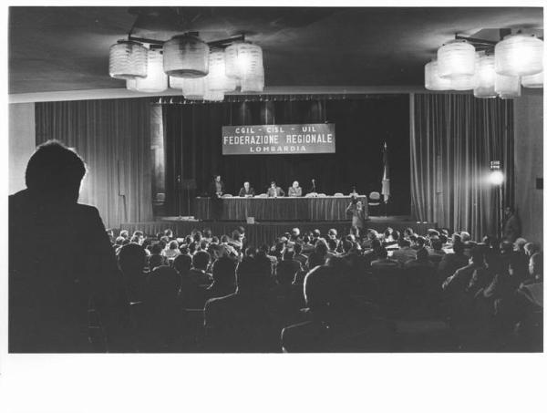 Teatro San Babila - Interno - Assemblea di costituzione della federazione regionale Cgil, Cisl, Uil - Panoramica sulla sala - Tavolo della presidenza e platea - Parola d'ordine