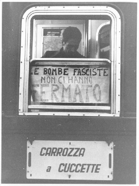 Manifestazione nazionale a Reggio Calabria per il Mezzogiorno e contro il fascismo - Stazione - Lavoratore sul treno in partenza da Milano per Reggio Calabria - Cartello