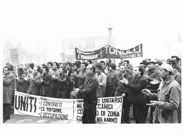 Sciopero nazionale dei metallurgici per il contratto, 40 manifestazioni di zona - Lavoratori al comizio applaudono - Operai con tuta da lavoro - Striscioni