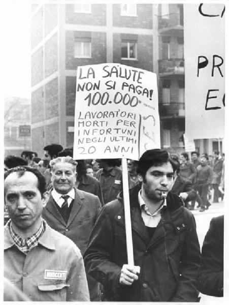 Manifestazione contro gli infortuni sul lavoro - Corteo - Operai con tuta da lavoro - Uomo con cartello