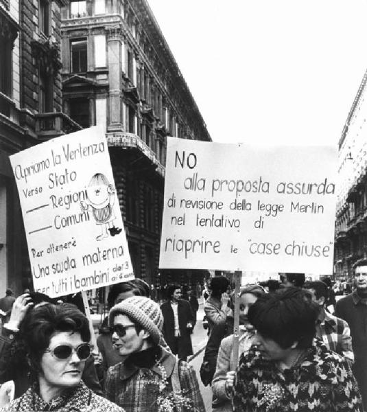 Manifestazione 8 marzo per la giornata internazionale della donna - Corteo - Donne con cartelli in difesa della scuola materna e contro la revisione della legge Merlin - Mimosa
