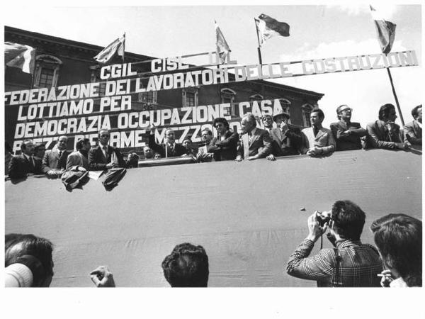 Sciopero nazionale dei lavoratori edili - Comizio in piazza San Giovanni - Palco - Bruno Storti, segretario generale Cisl, al microfono - Parola d'ordine - Bandiere