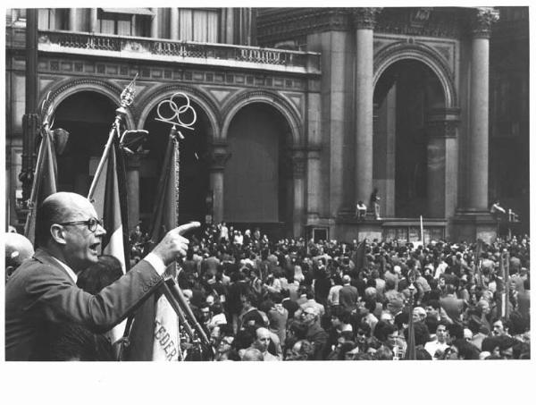 Manifestazione del primo maggio - Comizio in piazza del Duomo - Piero Boni al microfono - Folla di lavoratori - Gonfaloni - Bandiere