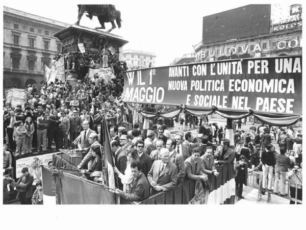 Manifestazione del primo maggio - Comizio in piazza del Duomo - Palco - Piero Boni al microfono - Monumento a Vittorio Emanuele II gremito di manifestanti - Parola d'ordine