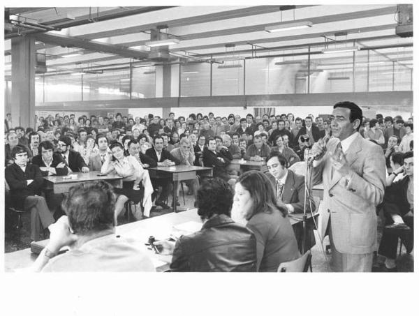 Gte - Interno - Assemblea congressuale in fabbrica - Rappresentante Uilm al microfono - Operai con grembiule da lavoro