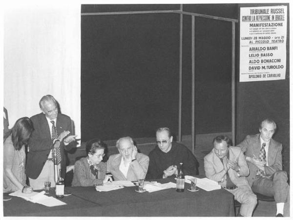 Piccolo Teatro - Interno - Manifestazione contro la repressione in Brasile - Tavolo della presidenza, tra gli oratori A. Banfi, L. Basso, D. M. Turoldo, A. Breschi, L. Banfi, A. De Carvalho - Manifesto