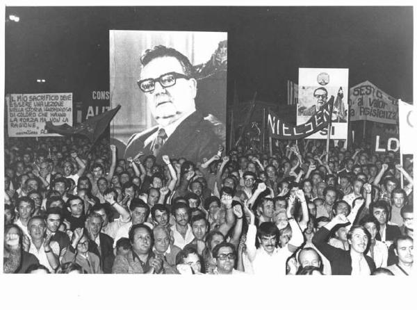 Manifestazione notturna per il Cile contro il colpo di stato - Comizio - Manifestanti salutano con il pugno chiuso - Striscioni - Cartelli - Bandiere - Fotografia di Salvador Allende