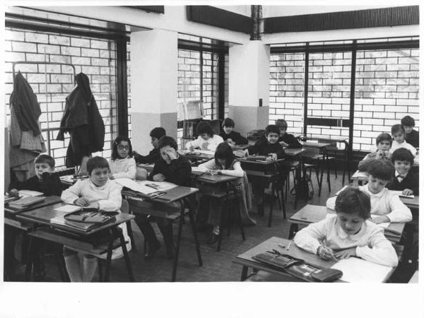 Scuola - Classe elementare in un negozio a Gratosoglio - Interno - Bambini dietro i banchi - Grembiule