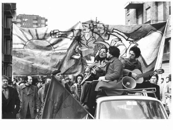 Sciopero generale - Corteo dei lavoratori - Manifestanti sul tetto di un auto con chitarra e microfono - Striscione - Bandiera