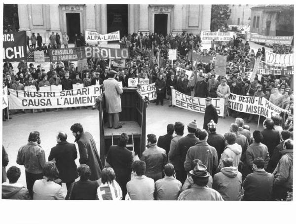 Sciopero generale - Comizio in piazza - Oratore sul palco - Lavoratori - Striscioni - Bandiere - Cartelli