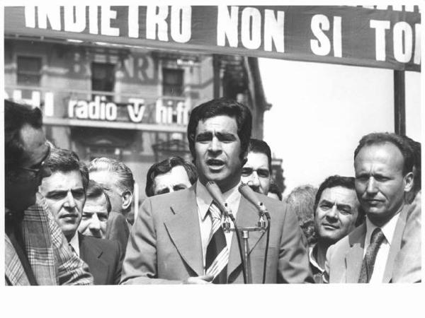 Manifestazione di tutte le categorie in risposta alla strage in piazza della Loggia a Brescia - Comizio in piazza del Duomo - Palco - Agostino Marianetti al microfono - Striscione - Pubblicità sui palazzi