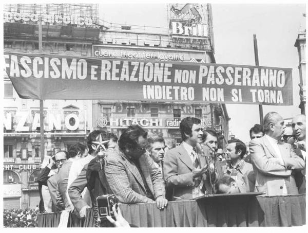 Manifestazione di tutte le categorie in risposta alla strage in piazza della Loggia a Brescia - Comizio in piazza del Duomo - Palco - Agostino Marianetti al microfono - Striscione - Pubblicità sui palazzi