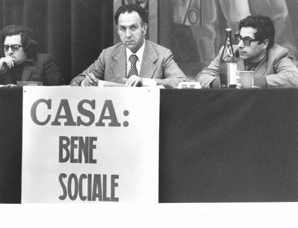 Convegno unitario edili per il problema della casa - Interno - Tavolo della presidenza, tra gli oratori Gustavo Scarpino - Manifesto