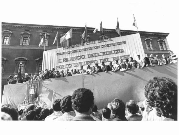 Manifestazione nazionale dei lavoratori edili - Comizio in piazza San Giovanni - Palco - Luciano Lama al microfono - Parola d'ordine - Bandiere - Gonfalone - Fotografi