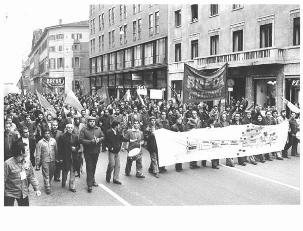 Sciopero dei lavoratori della Breda Siderurgica - Corteo in corso Venezia verso l'Intersind - Operai con tuta da lavoro, tamburo, piatti e campanaccio - Striscioni - Bandiere