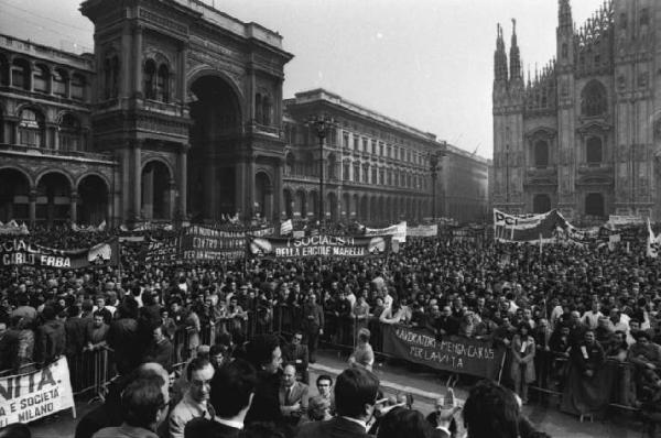 Sciopero generale dell'industria indetto dalla Federazione Cgil, Cisl, Uil - Comizio in piazza del Duomo - Panoramica sulla piazza - Folla di manifestanti - Striscioni - Sul palco di spalle G. Benvenuto - Ingresso della Galleria Vittorio Emanuele II