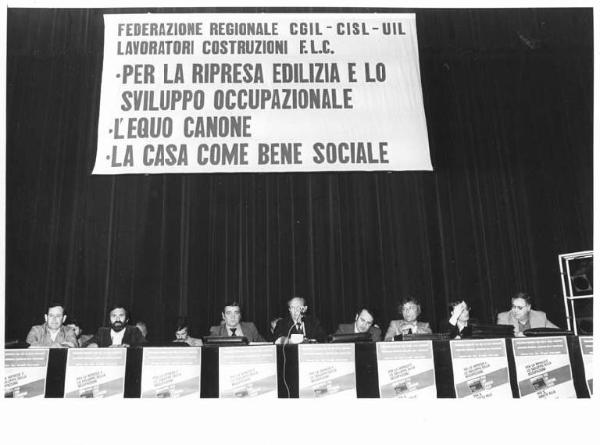 Teatro Lirico - Interno - Convegno regionale dei lavoratori delle costruzioni (edili) indetto da Cgil, Cisl e Uil - Palco - Tavolo della presidenza con oratori - Parola d'ordine