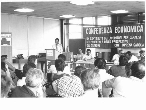 Conferenza economica del Consiglio di fabbrica dell'impresa Gadola - Interno - Tavolo della presidenza - Oratore al microfono - Parola d'ordine