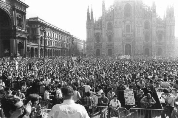 Sciopero generale dei lavoratori dell'industria per l'occupazione - Comizio in piazza del Duomo - Panoramica sulla piazza - Luciano Lama e Lucio De Carlini di spalle sul palco - Folla di manifestanti - Bandiere - Il Duomo