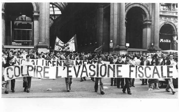 Sciopero generale dei lavoratori dell'industria in difesa dell'occupazione e della scala mobile - Corteo in piazza del Duomo - Lavoratori con striscione contro l'evasione fiscale - Bandiera