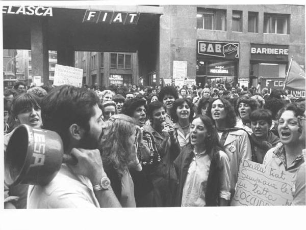 Sciopero dei lavoratori di diverse fabbriche contro i licenziamenti, per l'occupazione - Presidio davanti alla sede dell'Assolombarda - Operaie con grembiule di lavoro - Canto di lotta - Cartelli - Campanaccio - Bandiera