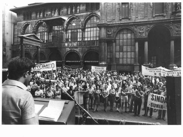 Manifestazione del sindacato inquilini (Sunia) - Piazza Mercanti - Comizio - Oratore di spalle al microfono - Manifestanti - Striscioni