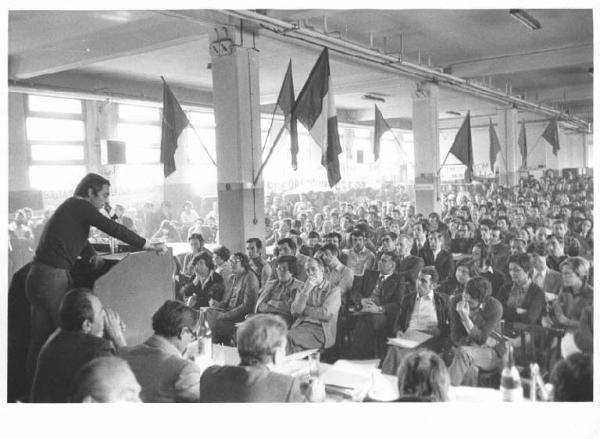 Ercole Marelli - Interno - Celebrazione del 30° anniversario della Liberazione - Assemblea: panoramica sulla sala - Oratore al microfono - Operai - Bandiere - Striscioni