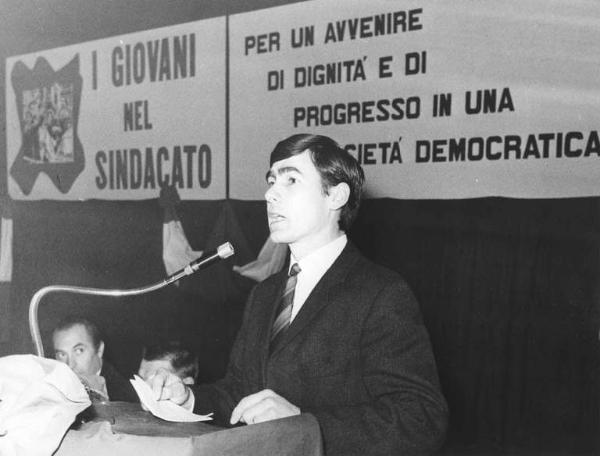 Camera del Lavoro - Salone "Di Vittorio" - Interno - Conferenza provinciale dei giovani metalmeccanici - Palco - Tavolo della presidenza con Leonardo Banfi e Antonio Pizzinato - Giovane al microfono - Parola d'ordine del congresso