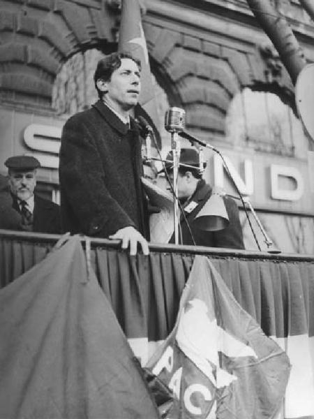 Manifestazione per la pace in Vietnam - Piazza Castello - Comizio - Palco - Relatore al microfono - Sul palco Lelio Basso - Bandiera della pace