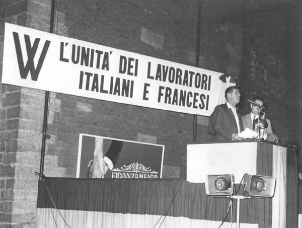 Manifestazione per i lavoratori francesi - Comizio - Palco - Oratore al microfono - Parola d'ordine