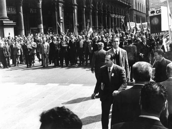 Manifestazione del primo maggio - Corteo dei lavoratori in piazza del Duomo - In prima fila i dirigenti sindacali tra i quali: Guido Venegoni, Pierluigi Perotta, Lauro Casadio, Leonard Banfi - Cartelli - Bandiere