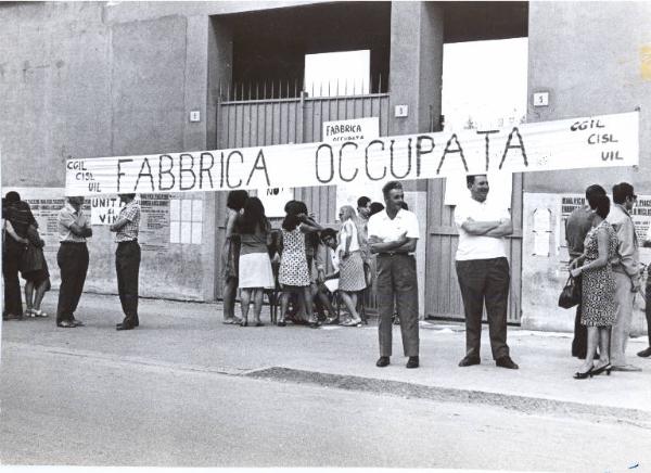 Milano - Maglificio Piacentino - Fabbrica occupata - Lavoratrici davanti ai cancelli della fabbrica - Striscione di Cgil, Cisl, Uil