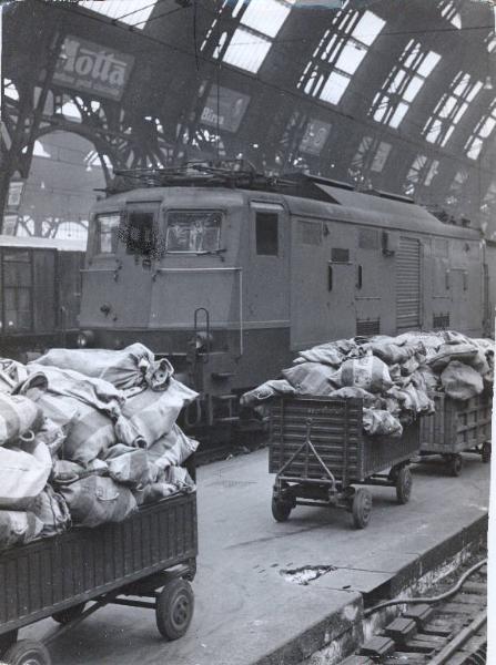 Milano - Sciopero postelegrafonici - Stazione Centrale - Interno - Marciapiede dei binari - Carrelli carichi di sacchi di posta - Locomotiva