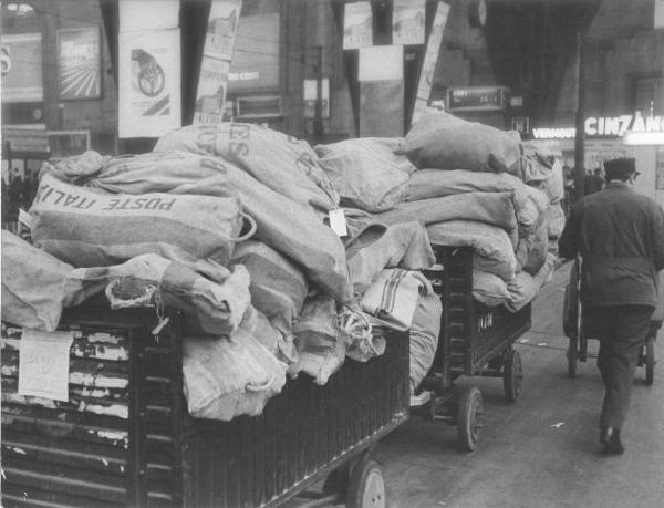 Milano - Sciopero postelegrafonici - Stazione Centrale - Interno - Banchina - Carrelli carichi di sacchi di posta - Facchino - Cartelli pubblicitari