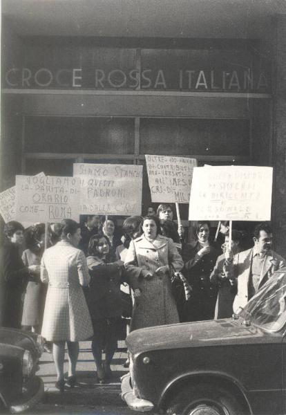 Milano - Sciopero infermiere - Via Pucci - Presidio delle lavoratrici davanti all'ingresso della sede della Croce Rossa Italiana (CRI) - Ritratto di gruppo - Infermiere con cartelli di protesta - Insegna "Croce rossa italiana"