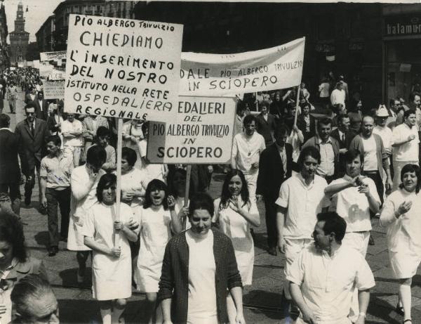 Milano - Sciopero ospedalieri - Corteo in via Dante - Spezzone lavoratori del Pio albergio Trivulzio - Lavoratori in camice con cartelli sindacali e di protesta - Sullo sfondo il Castello Sforzesco