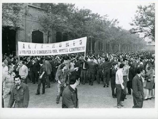 Sciopero dei lavoratori dell'Alfa Romeo per il contratto - Corteo nelle vie attorno allo stabilimento - Operai con tuta da lavoro - Striscione