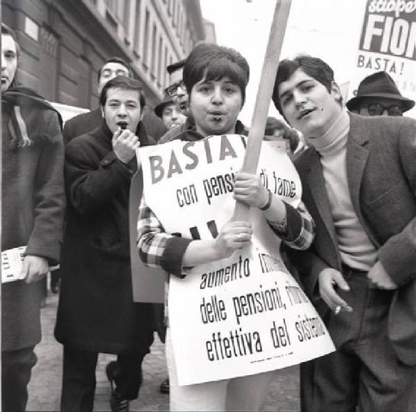 Sciopero dei lavoratori metalmeccanici per le pensioni - Lavoratori al corteo con fischietti - Donna in primo piano con cartello di protesta