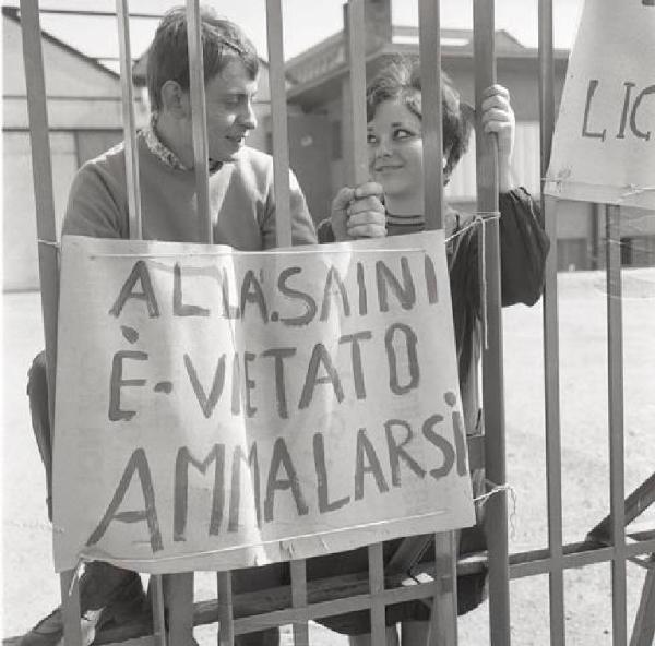 Saini - Occupazione della fabbrica contro i licenziamenti - Lavoratori dietro al cancello - Cartello di protesta contro l'azienda