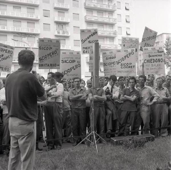 Sciopero dei lavoratori edili della Sicop - Comizio - Oratore al microfono - Lavoratori - Cartelli di sciopero Cgil, Cisl, Uil