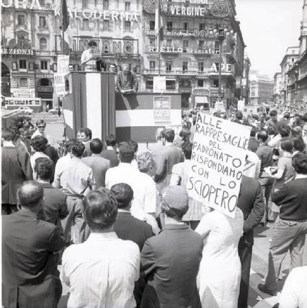 Sciopero provinciale dei metallurgici contro le rappresaglie padronali e per la libertà in fabbrica - Corteo in Piazza Duomo - Palco - Oratore al microfono - Cartelli di protesta