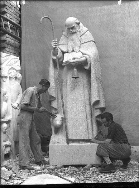 Riproduzione di opera d'arte. Scultura di Giuseppe Enrini: S. Antonio Abate - monumento funebre Bernasconi / doppio ritratto maschile. Giuseppe Enrini e assistente